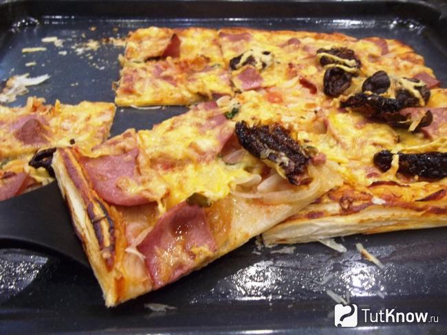 Готовая пицца из слоеного теста с колбасой, сыром и вялеными помидорами