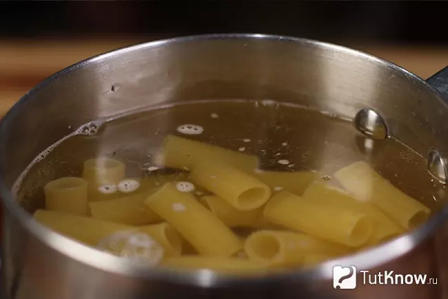 Паста ригатони варится в кастрюле в кипящей подсоленной воде