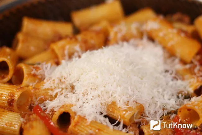 Тёртый сыр Грана Падано или пармезан, насыпанный сверху на горячую пасту