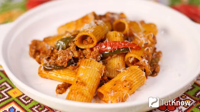 Готовая паста ригатони с фаршем и сладким перцем, поданная на тарелке