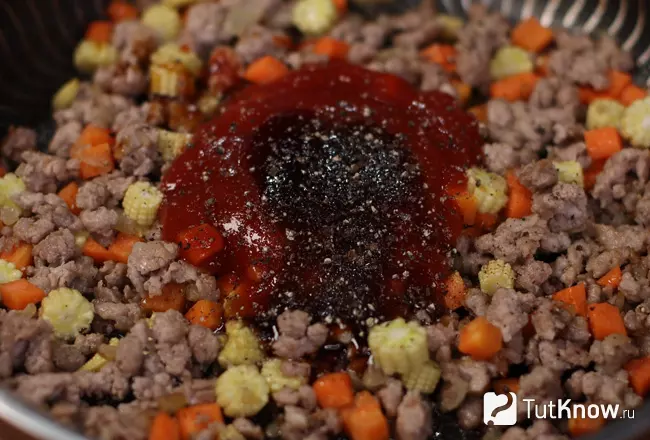 Добавление кетчупа, соусов и черного молотого перца к фаршу
