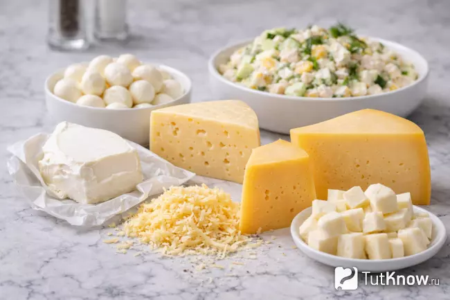 Салат с курицей и сыром и разные виды сыра на столе