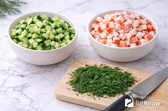 Шаг 2 - нарезанные крабовые палочки, огурец и укроп для салата