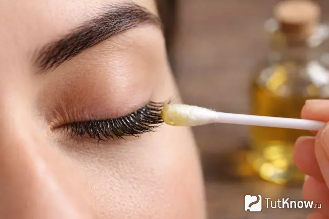 Нанесение касторового масла на ресницы ватной палочкой