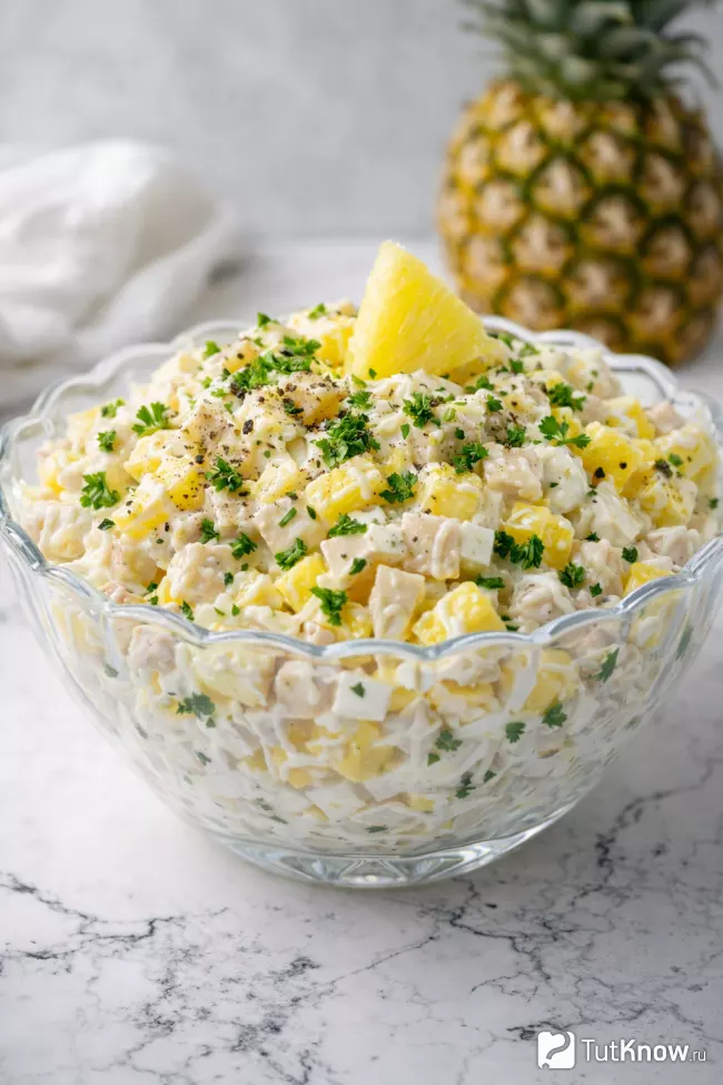 Салат с ананасом, курицей и сыром в стеклянной салатнице