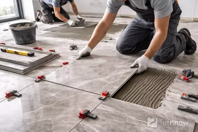 Процесс укладки керамогранита на пол в комнате