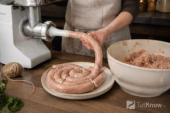 Процесс наполнения куриных купатов через мясорубку с насадкой для колбас